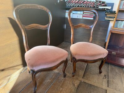 pair of antique chairs with pink upholstered upholstered cushions
