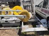 a truck that is parked next to a truck with a brush on it