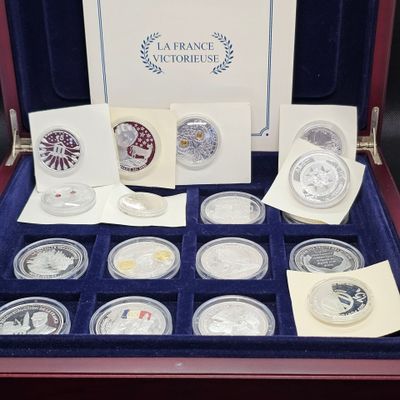 un assortiment de pièces d'argent présenté dans un coffret, accompagné de cartes et d'enveloppes