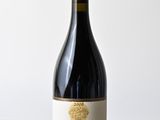 a bottle of wine sitting on top of a wooden table