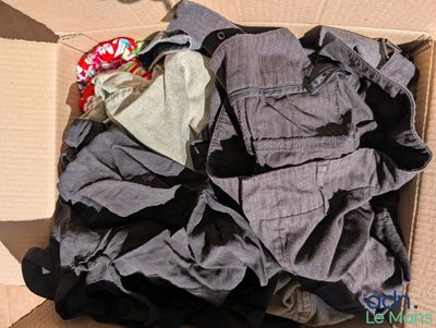 une boîte pleine de vêtements posée sur le sol