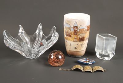un vase en verre, un bougeoir en verre et une boule en verre posés sur une table