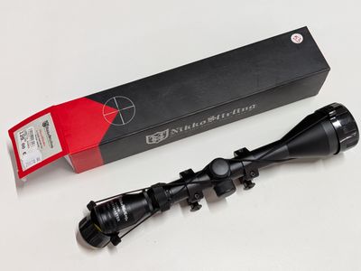 a close up of a rifle scope with a box on a table