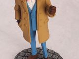 une figurine représentant un homme en manteau et nœud papillon