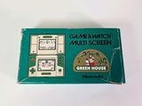 a game and watch in a green box on a white surface