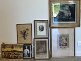 de nombreux tableaux encadrés accrochés au mur, à côté d'un chat