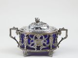 an antique silver and blue glass covered dish with a bird on top