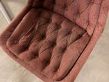 a pink chair that is sitting in a room