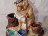 une figurine représentant un homme avec un chapeau et une canne
