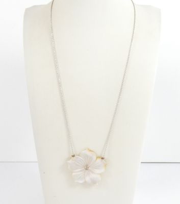 a white necklace with a flower pendant on a mannequin