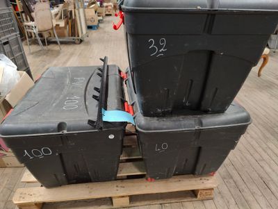 deux boîtes noires posées sur une palette dans un entrepôt