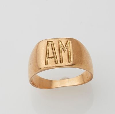 a close up of a gold ring with the letter m on it
