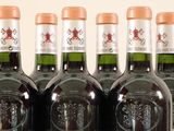 six bottles of wine are lined up in a row on a table