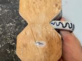 a person holding a piece of wood with a marker on it