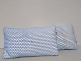 two blue pillows sitting on top of a table next to each other