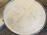 a drum on the floor next to a drum stand