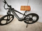 un vélo garé dans un garage, avec une boîte posée sur la selle