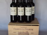 quatre bouteilles de vin rouge dans un coffret en bois posé sur une table