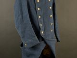 a blue uniform with gold buttons and a red bow tie on a mannequin