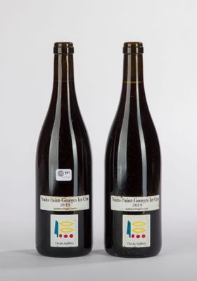 two bottles of wine sitting next to each other on top of a table