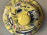 a yellow plate with a blue and white bowl on it