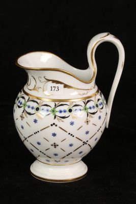 a white pitcher with blue flowers on it on a black background
