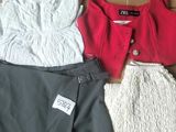 trois vêtements disposés sur une boîte en carton, avec une étiquette de prix