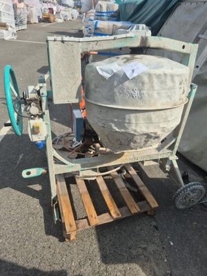 a cement mixer sitting on a pallet in a parking lot