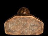 statue of a man sitting on top of a stone block with a black background