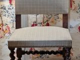 a chair that is sitting in front of a wallpapered wall