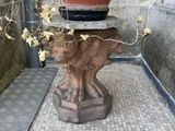 a potted plant sitting on top of a bear statue