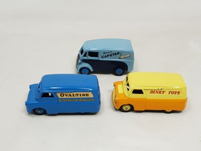 three toy cars sitting next to each other on a white surface