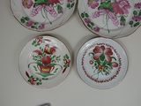 three plates with floral designs are on a table next to a remote control