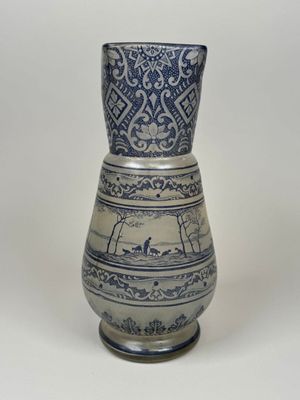 un vase bleu et blanc posé sur une surface blanche
