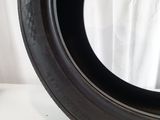 a close up of a tire on a table with a white curtain in the background