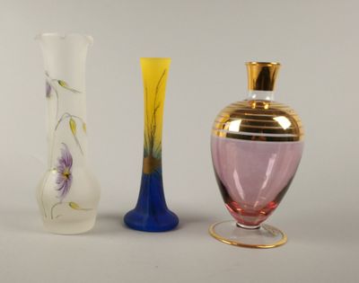 trois vases en verre posés l'un à côté de l'autre sur une table