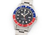 a close up of a wrist watch with a red, white and blue bezel