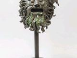 a statue of a man with a green face on a stand