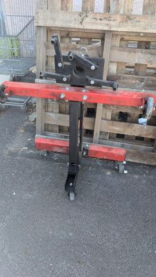 une photo d'une machine rouge et noire posée sur une palette en bois