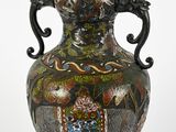 un vase noir orné d'un motif, posé sur une table