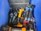 de nombreux outils divers dans un bac bleu posé par terre