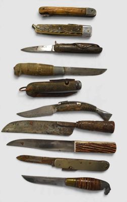 several different types of knives are lined up on a white surface