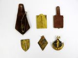several pieces of brass and leather are arranged on a white surface