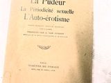 un vieux livre posé sur une table à côté d'une tasse de café