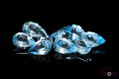 three pieces of blue topazte on a black surface