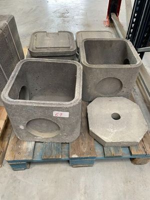 plusieurs conteneurs en béton posés sur une palette dans un entrepôt
