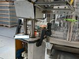 une photo d'une machine dans un entrepôt, avec des palettes en arrière-plan