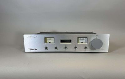 a close up of a silver radio on a white surface