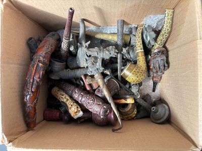 une boîte en carton remplie d'objets divers, comme des armes à feu et des couteaux