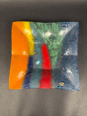 a colorful glass plate sitting on top of a table